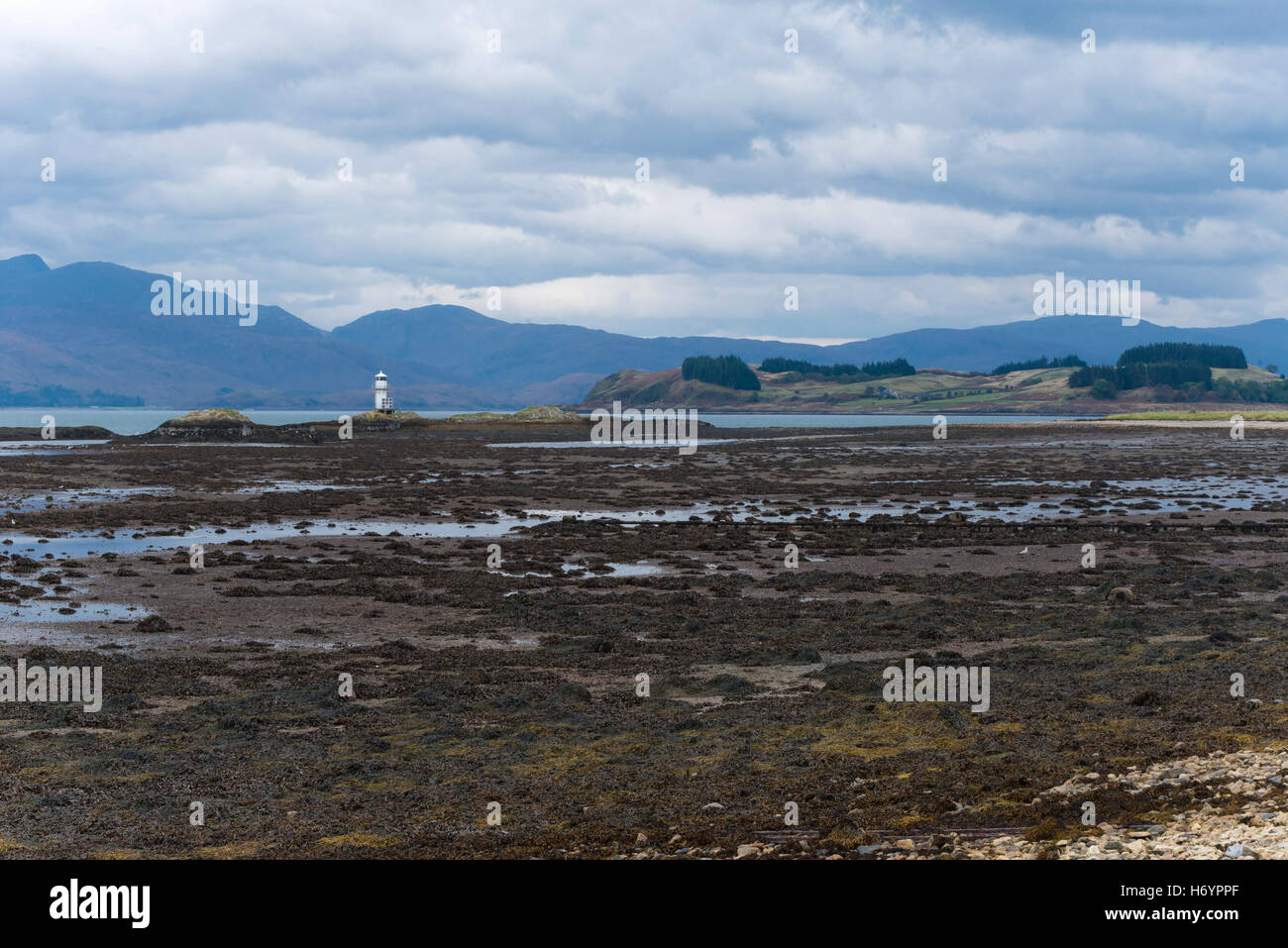 View from port appin over to Creach Bheinn with lighthouse in foreground and tide out Stock Photo