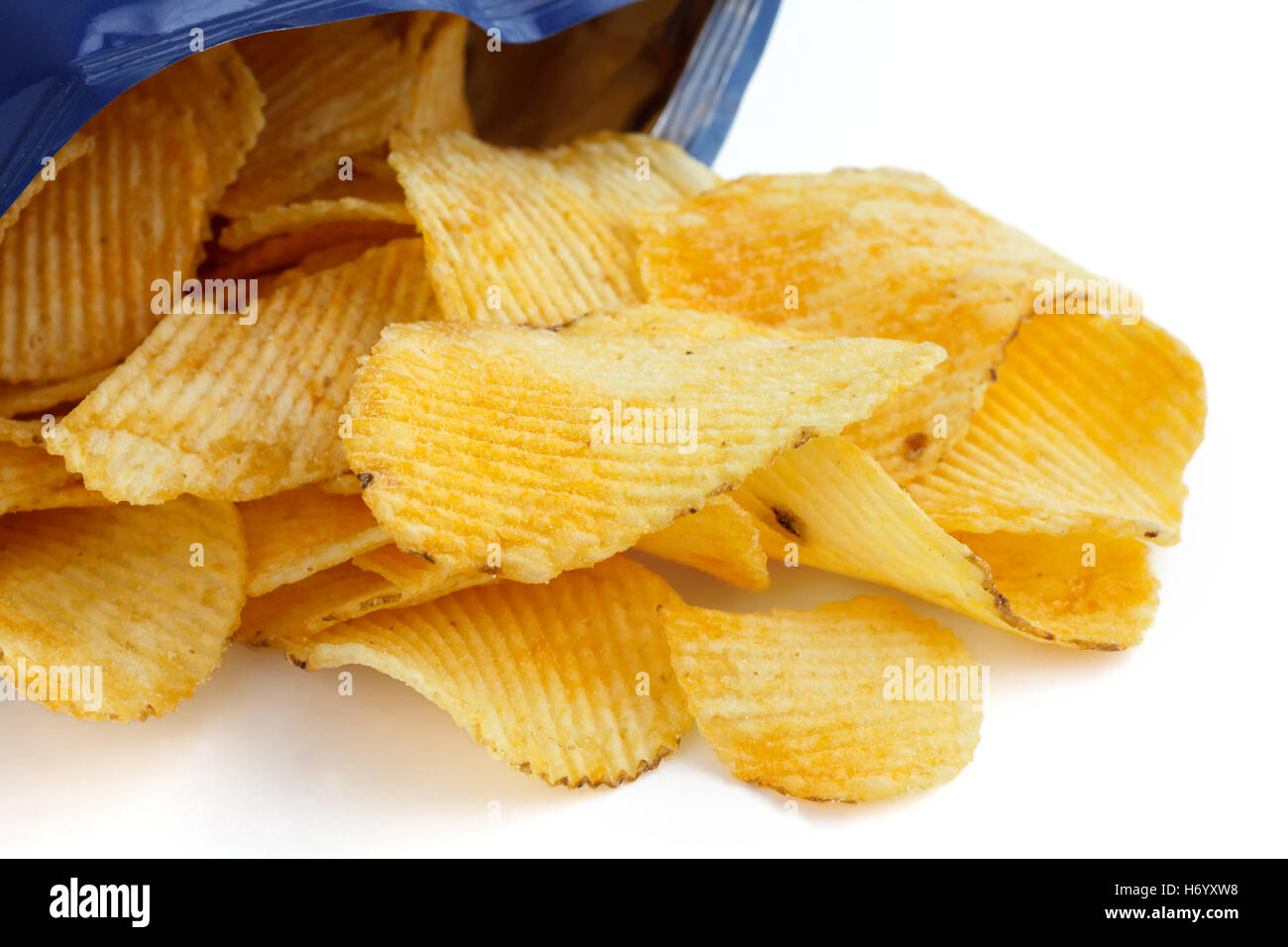Crinkle cut crisps spilling out of a foil packet. Stock Photo