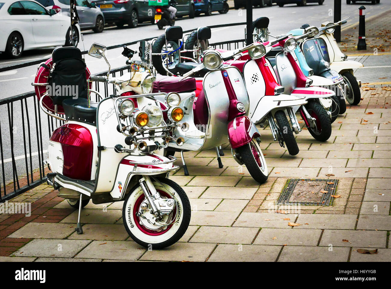 A line up of Vespa and Lambretta scooters in Wanstead High Street, London Stock Photo