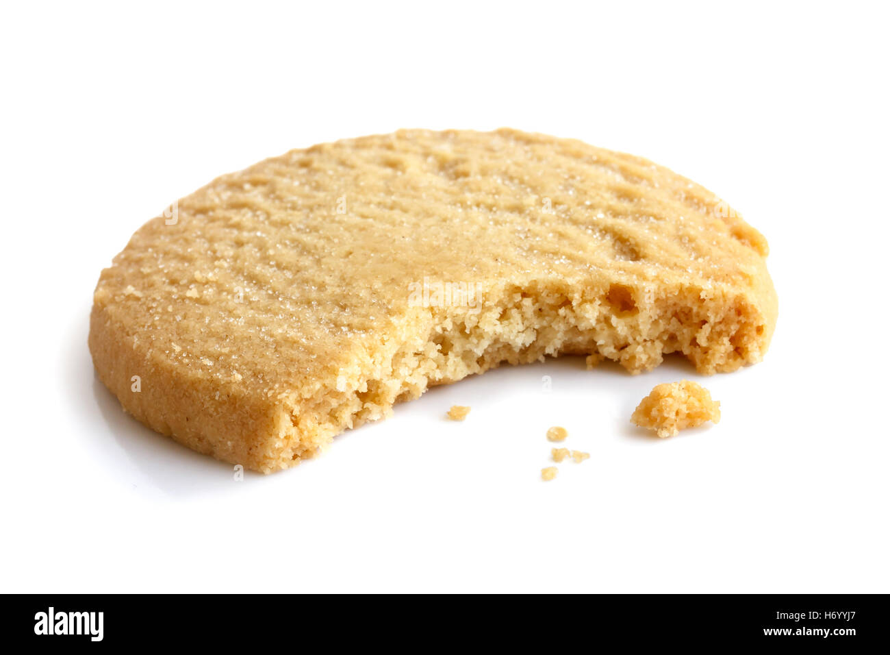 Single round shortbread biscuit with crumbs and bite missing. In perspective. Stock Photo