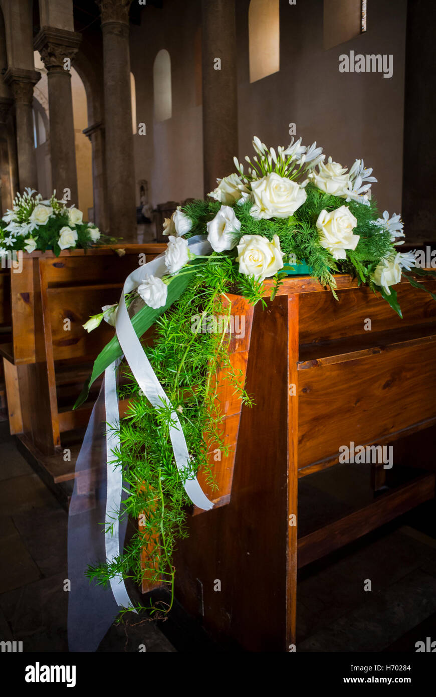 Cefalu, Sicily, Italy,Bouquets of white flowers put on a chair inside a Cathedral of Cefalu( Duomo di Cefalu) that is a Roman Catholic basilica Stock Photo