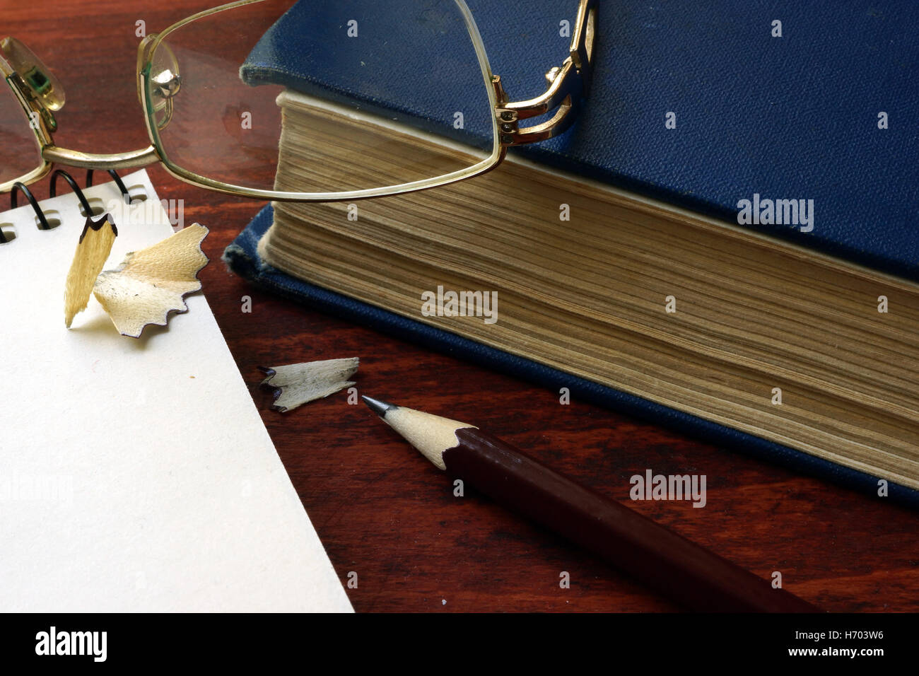 Pencil with glasses and books on wooden table. Stock Photo