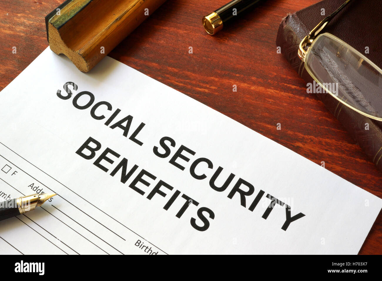 Social security benefits form, book and glasses. Stock Photo