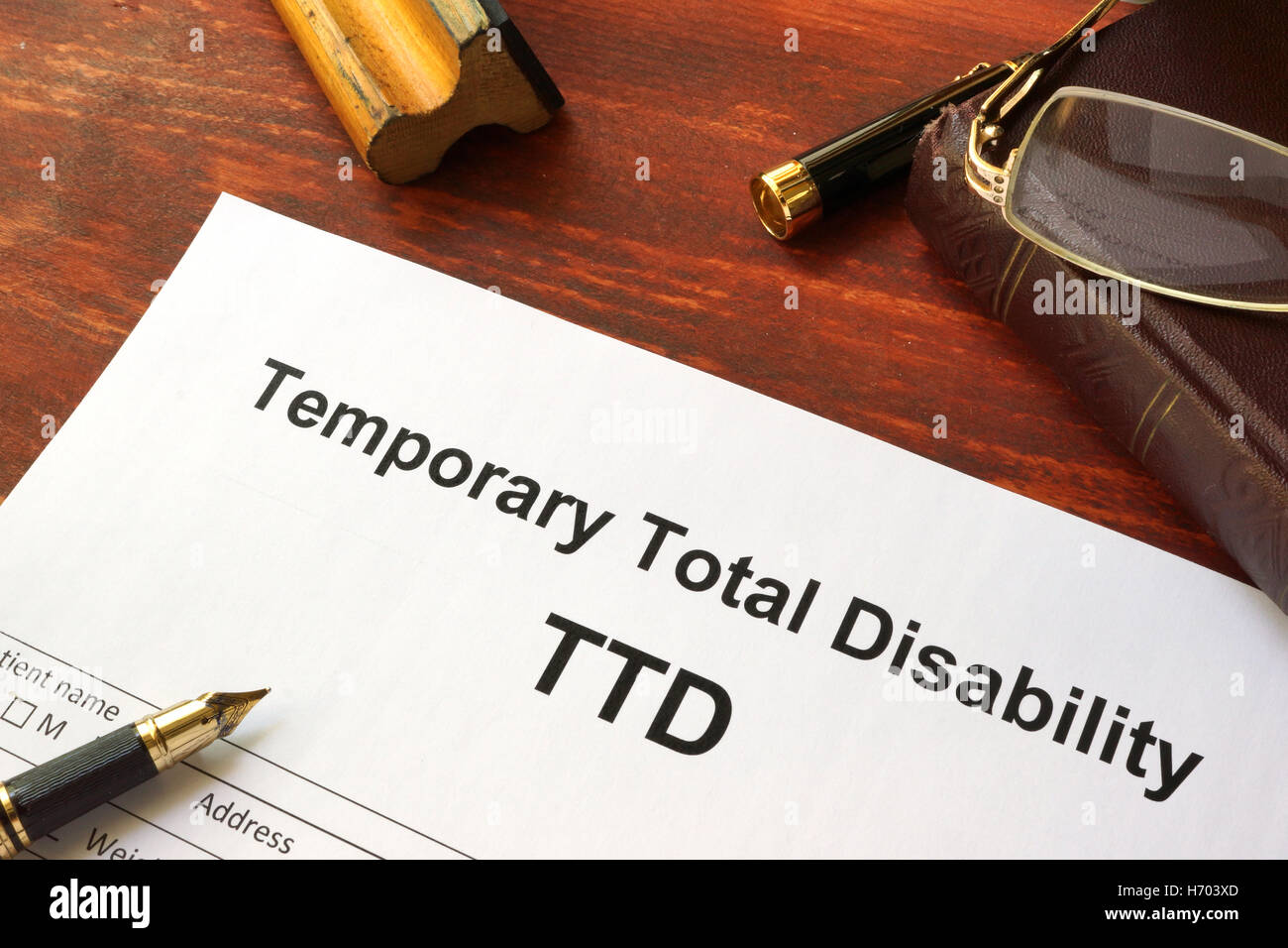 Temporary Total Disability (TTD) form on a wooden table. Stock Photo