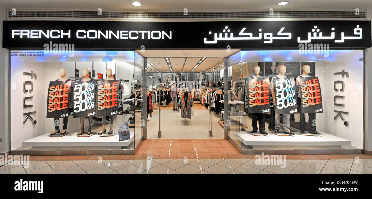 Middle East UAE Abu Dhabi Marina shopping mall French Connection brand fashion clothing shop front window with bilingual store signs and fcuk sign Stock Photo