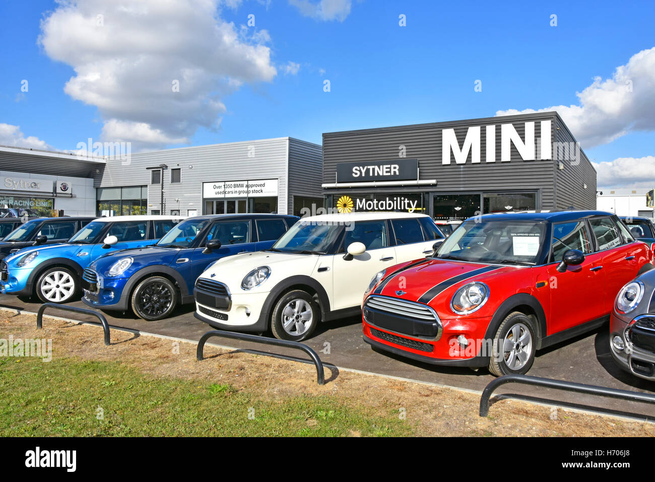 Row of used car dealers second hand BMW Mini cars for sale on garage forecourt in front of Sytner dealership showroom London England UK Stock Photo