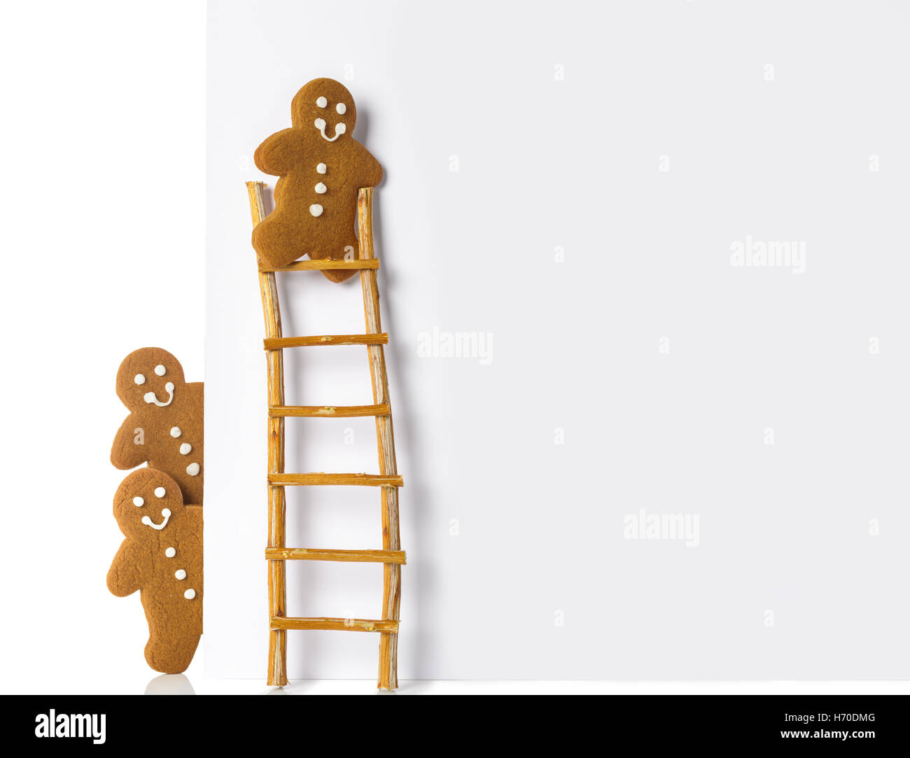 Gingerbread man up a ladder of advertising board Stock Photo