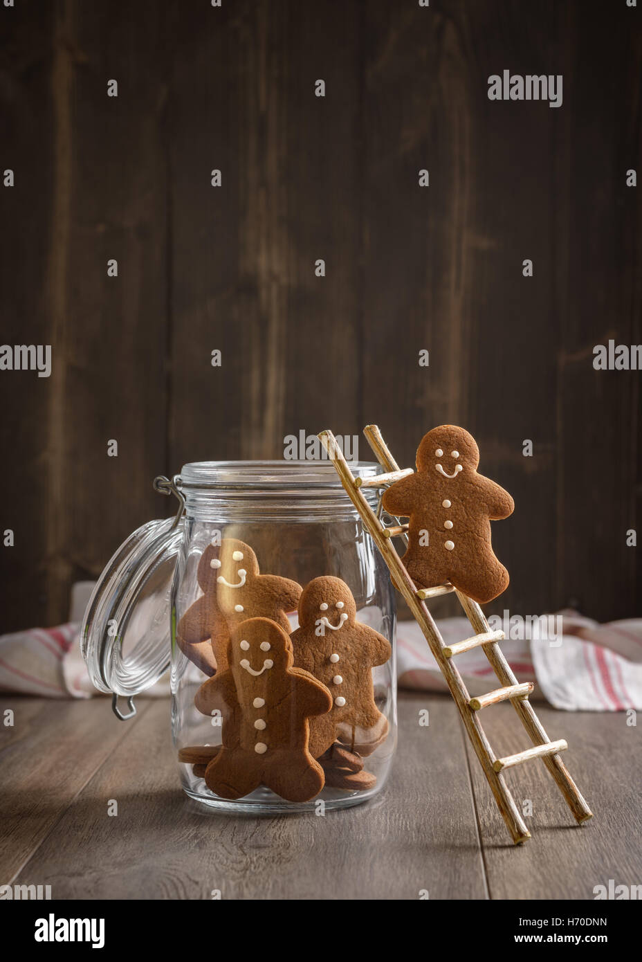 Gingerbread man on rustic ladder climbing into cookie jar Stock Photo