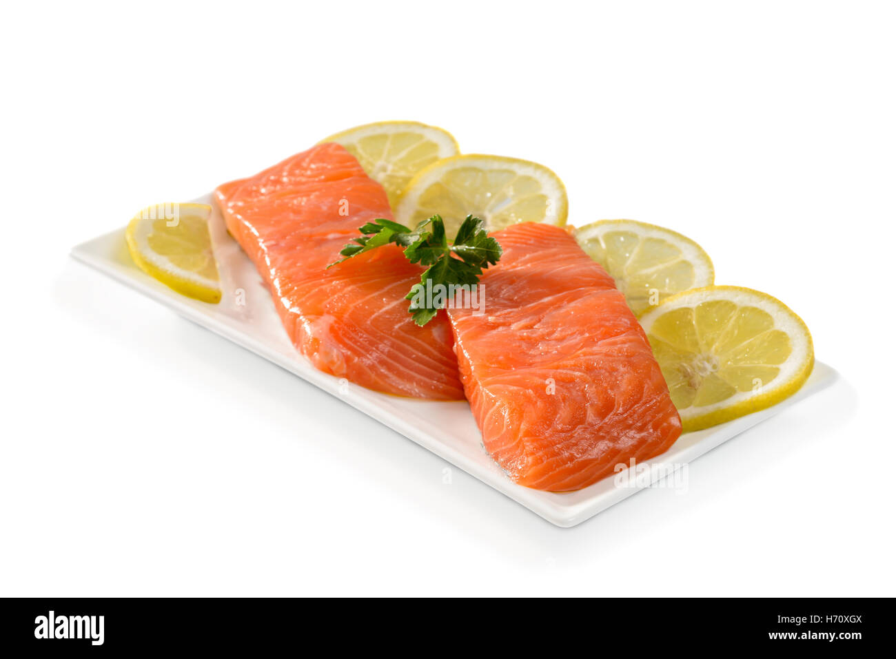 Salmon fillets with lemon slices on a white background Stock Photo