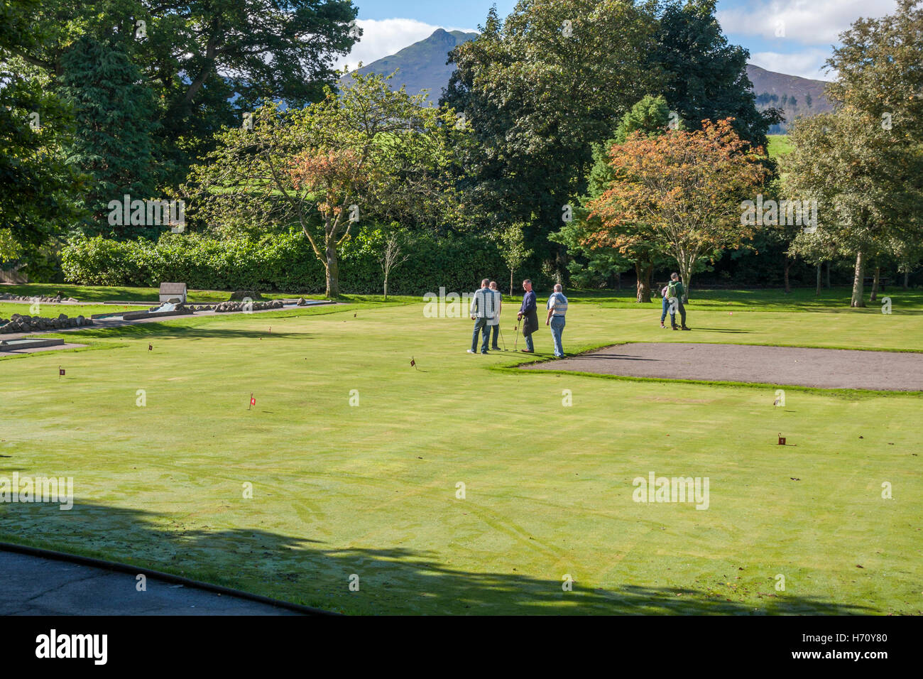 People enjoying a game of putt at Hope Park,Keswick with Catbells in