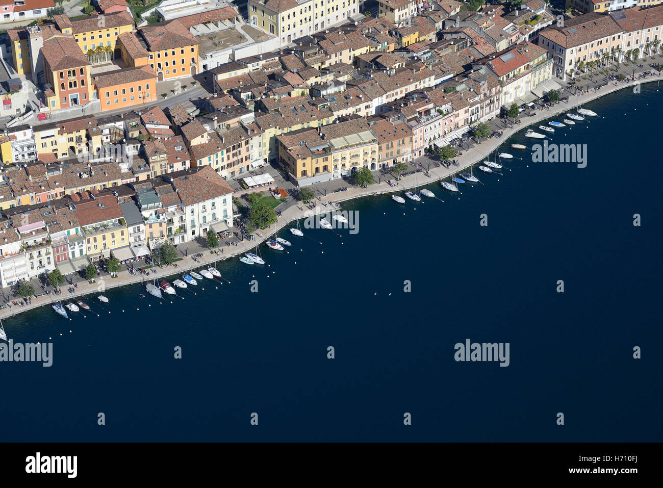 AERIAL VIEW. Picturesque town with its row of boats on the lakeshore of Lake Garda. Salò, Province of Brescia, Lombardy, Italy. Stock Photo