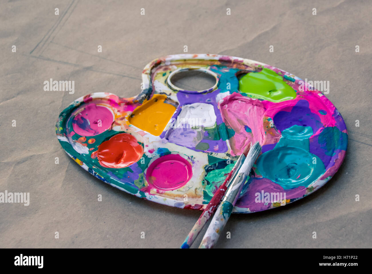Photograph of an art palette with paint and brushes Stock Photo