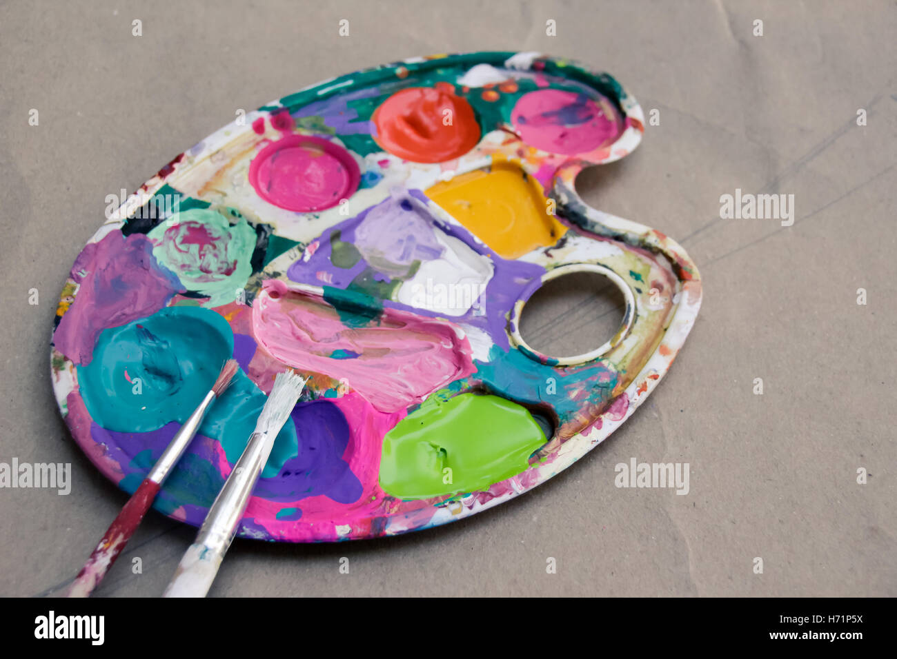 Photograph of an art palette with paint and brushes Stock Photo