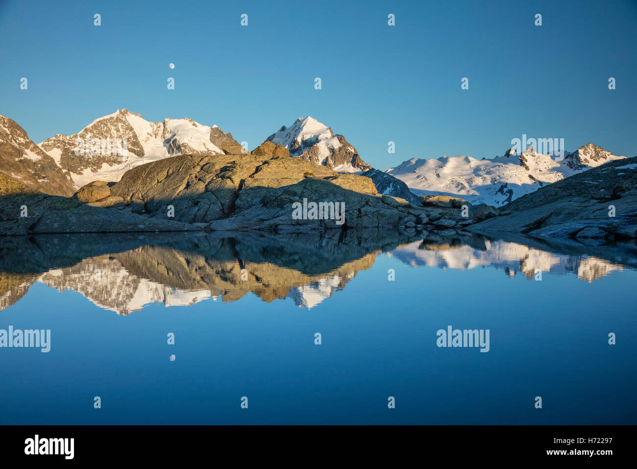 Reflection of moonrise over Piz Bernina and Piz Rosbeg, Fuorcla Surlej, Silvaplana. Berniner Alps, Graubunden, Switzerland. Stock Photo