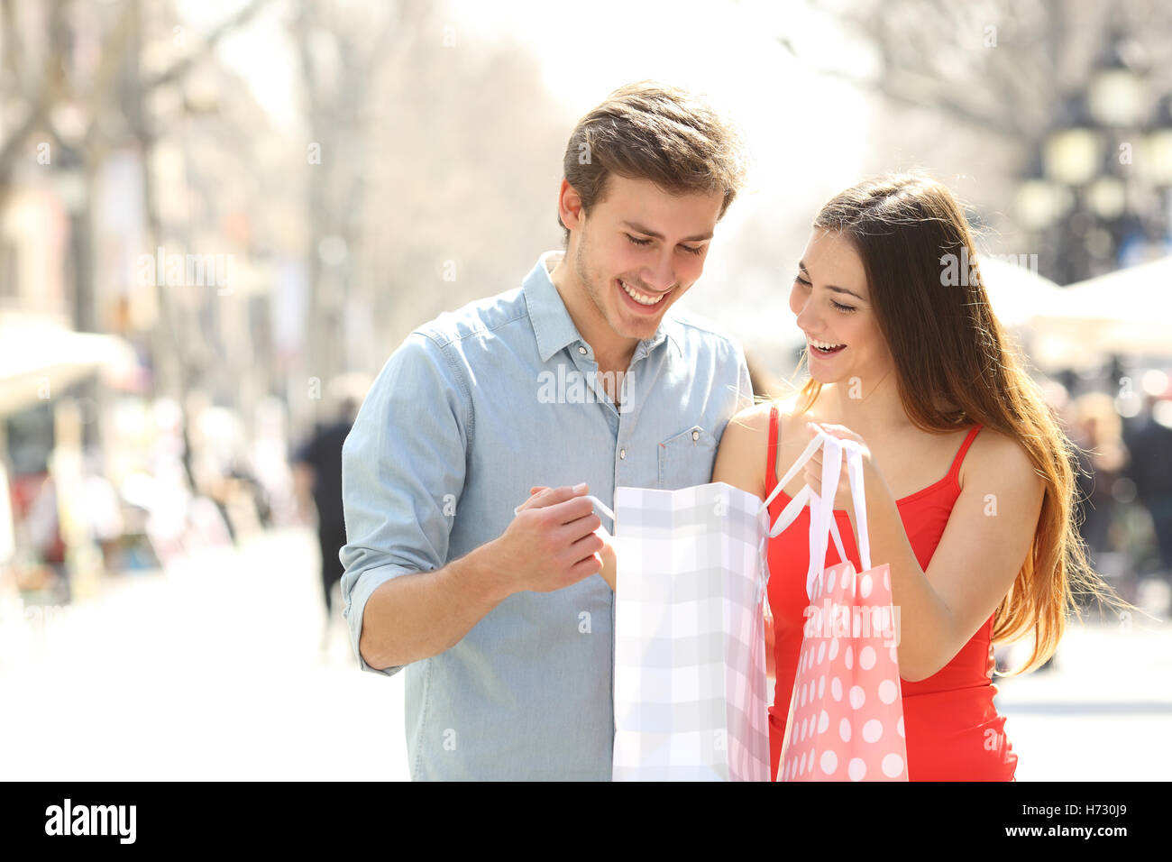 Couple shopping and holding bags in the street Stock Photo
