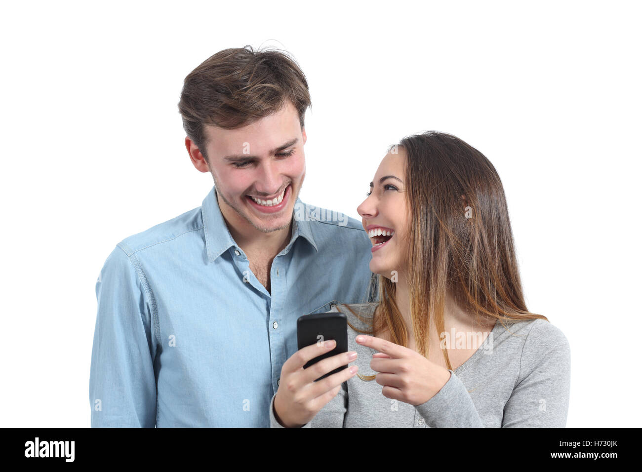 Happy friends laughing and watching a smart phone Stock Photo