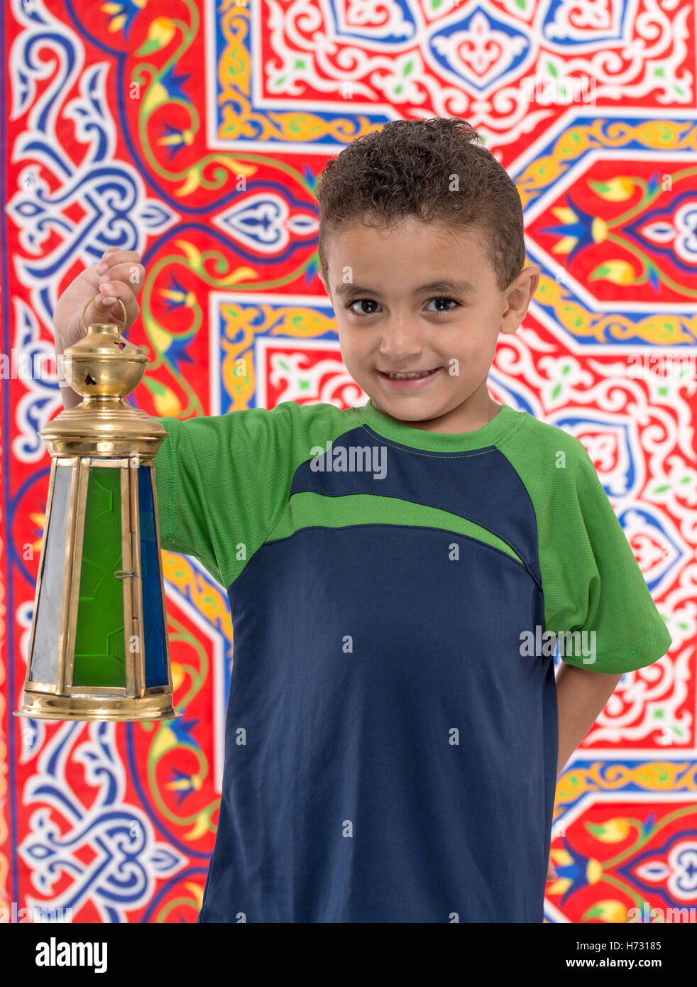 Adorable Young Boy with Large Ramadan Lantern over Ramadan Fabric Stock Photo