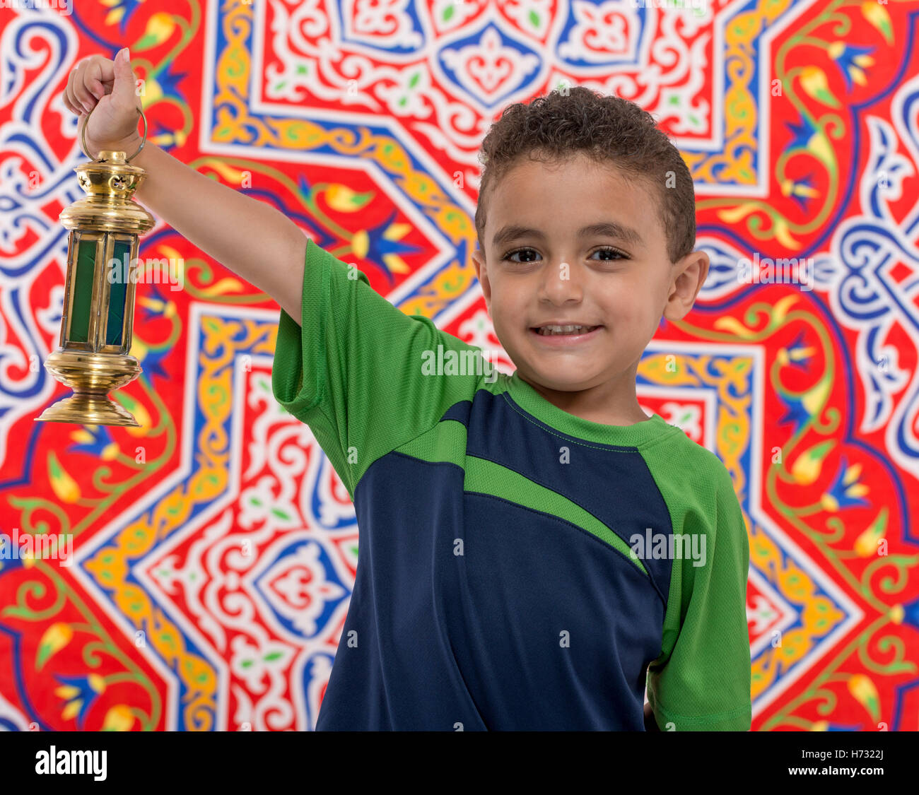 Adorable Boy with Vintage Lantern over Festive Ramadan Fabric Stock Photo