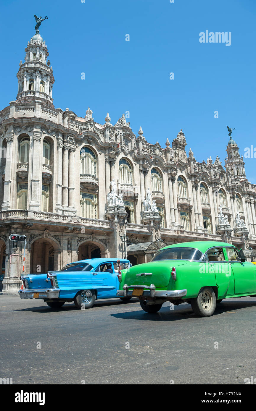 HAVANA, CUBA - JUNE 13, 2011: Brightly colored vintage American cars pass in front of the Great Theater of Havana. Stock Photo
