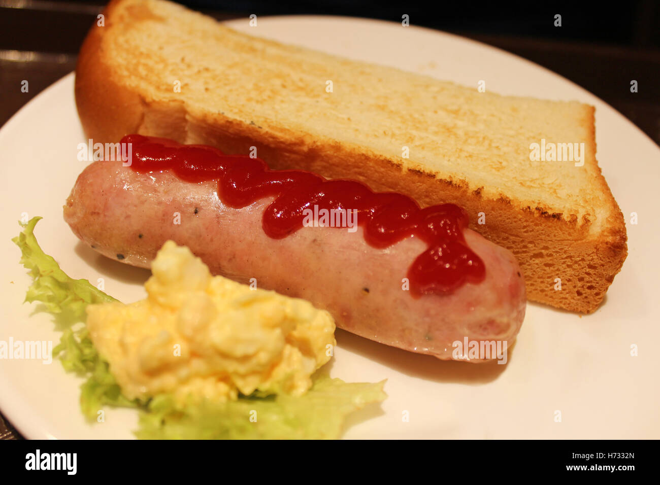 A Freshly Grilled Hotdog With A Stream Of Ketchup Butter Toast Bread And Egg Scramble On A Plate Stock Photo Alamy