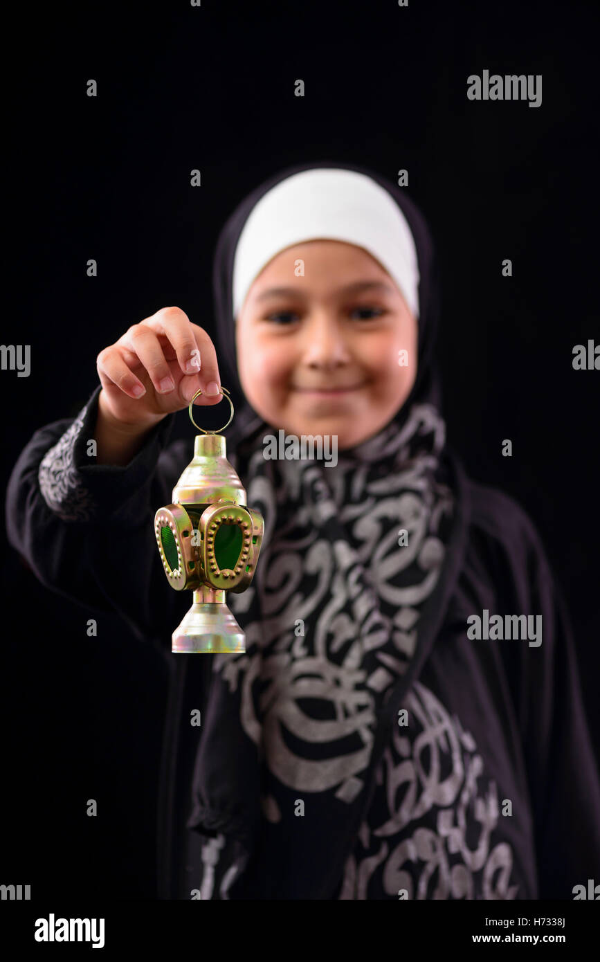 Happy Muslim Girl with Ramadan Lantern on Defocused Night Lights Background Stock Photo