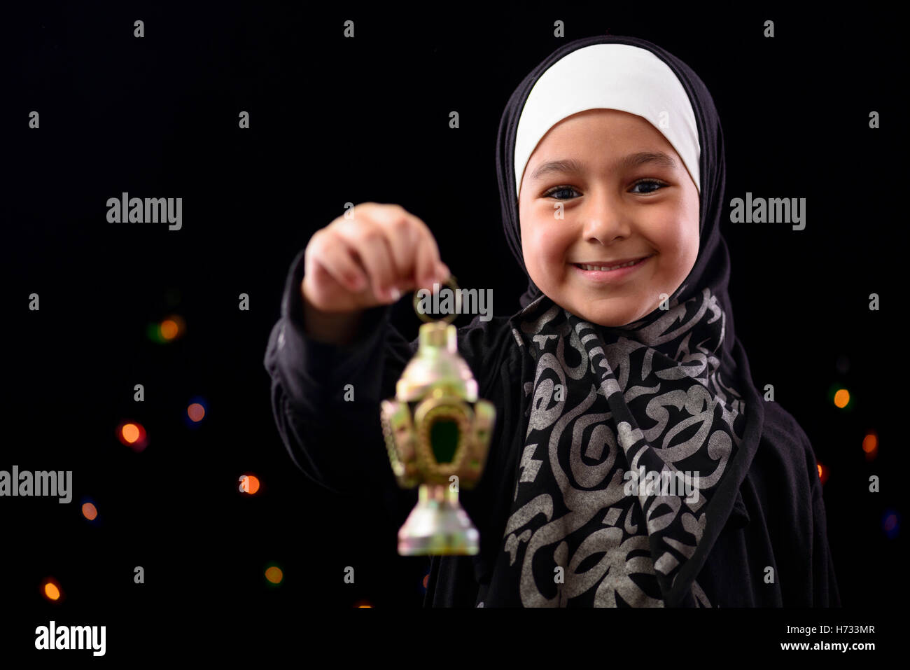 Happy Muslim Girl Celebrating Ramadan on Defocused Night Lights Background Stock Photo