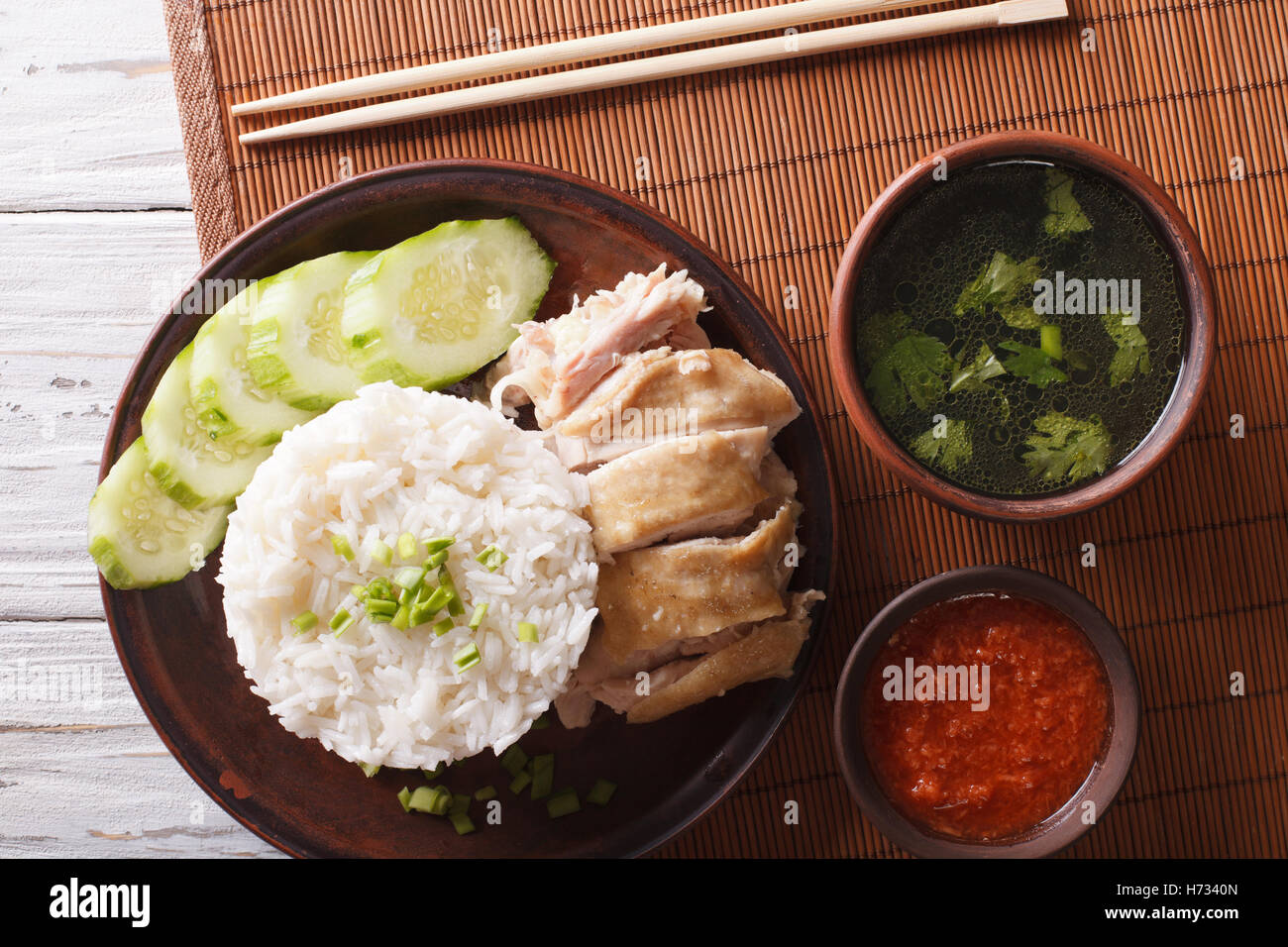 Hainanese chicken rice, chilli sauce and bouillon on the table closeup. Horizontal view from