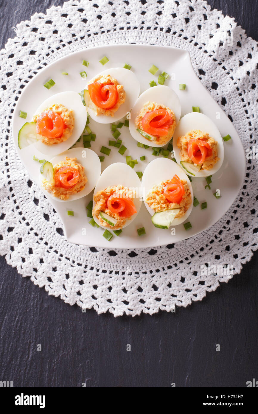 Eggs stuffed with salmon, cheese and cucumber on a table. vertical view