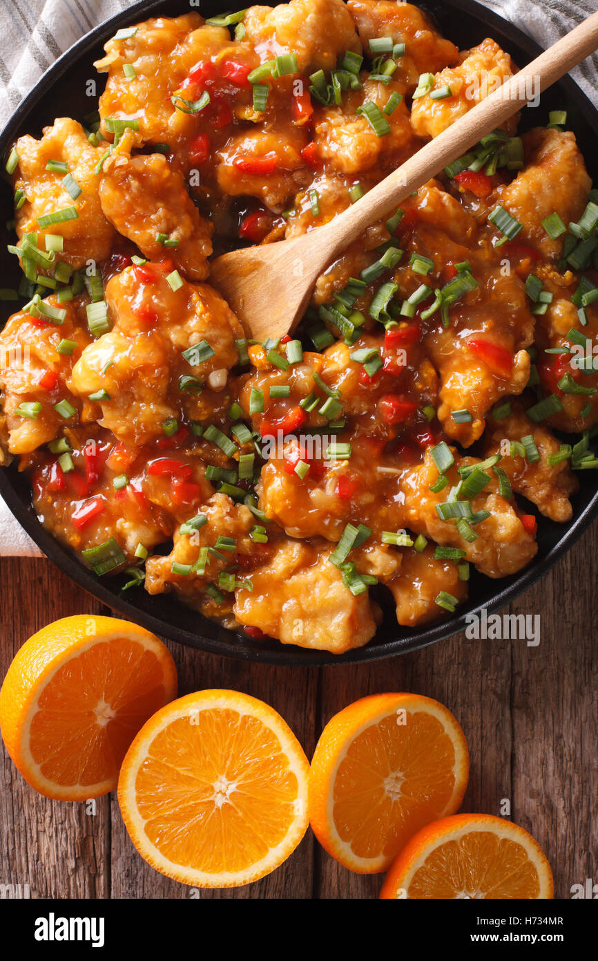 Delicious orange chicken fillets close-up on a plate on the table. vertical view from above Stock Photo