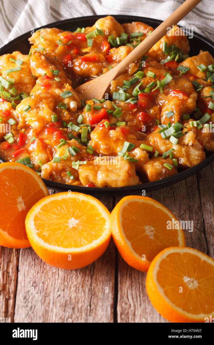 Delicious orange chicken fillets close-up on a plate on the table. vertical Stock Photo