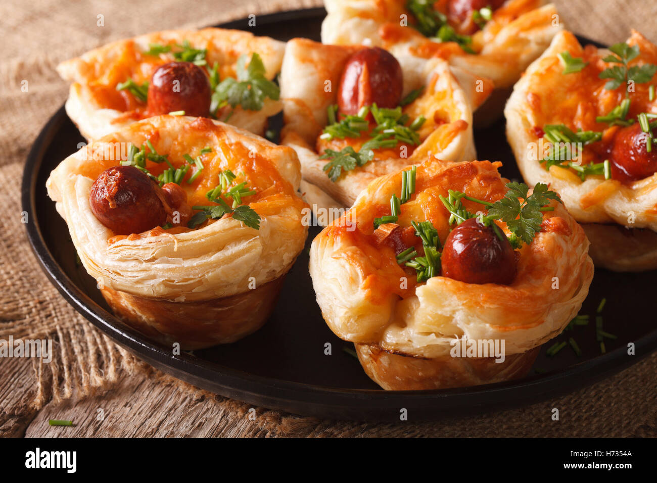 Tasty muffins with sausage and cheese on a plate close-up. horizontal Stock Photo