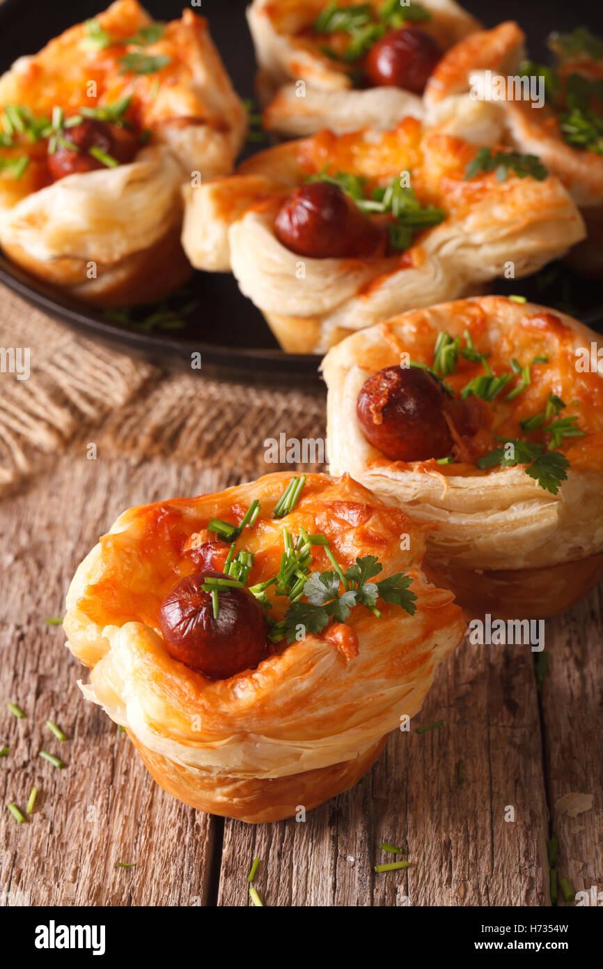 buns of puff pastry with sausage and cheese close-up on the table. vertical Stock Photo