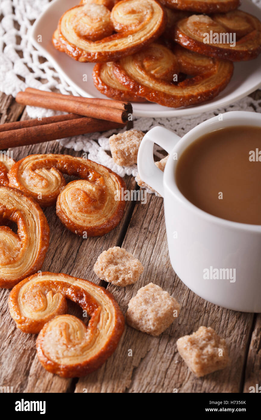 cookies of puff pastry Palmiers and coffee with milk close-up on a table, vertical Stock Photo