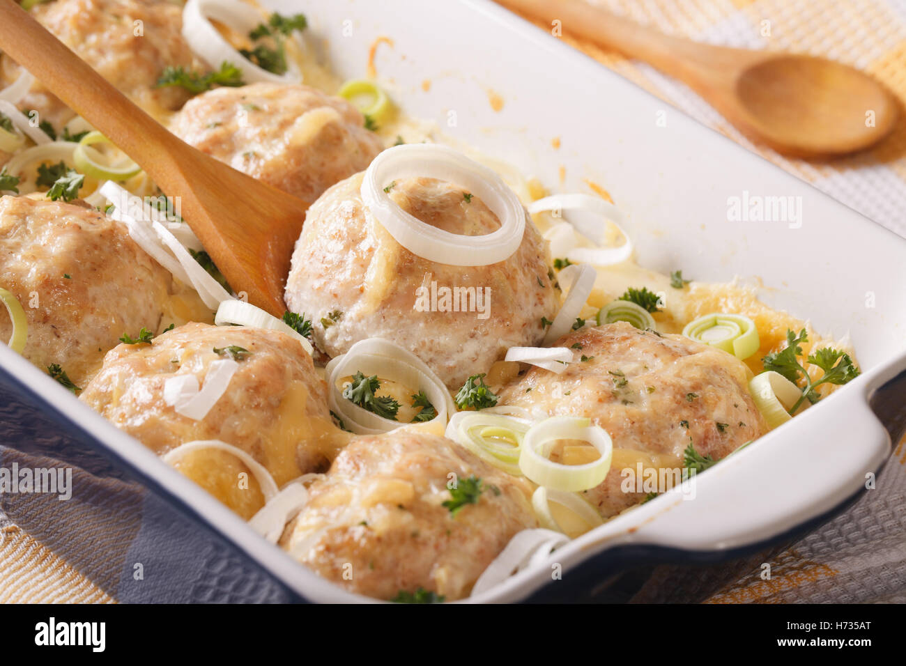 Tasty chicken balls baked in cheese cream sauce close-up in the dish for baking. horizontal Stock Photo