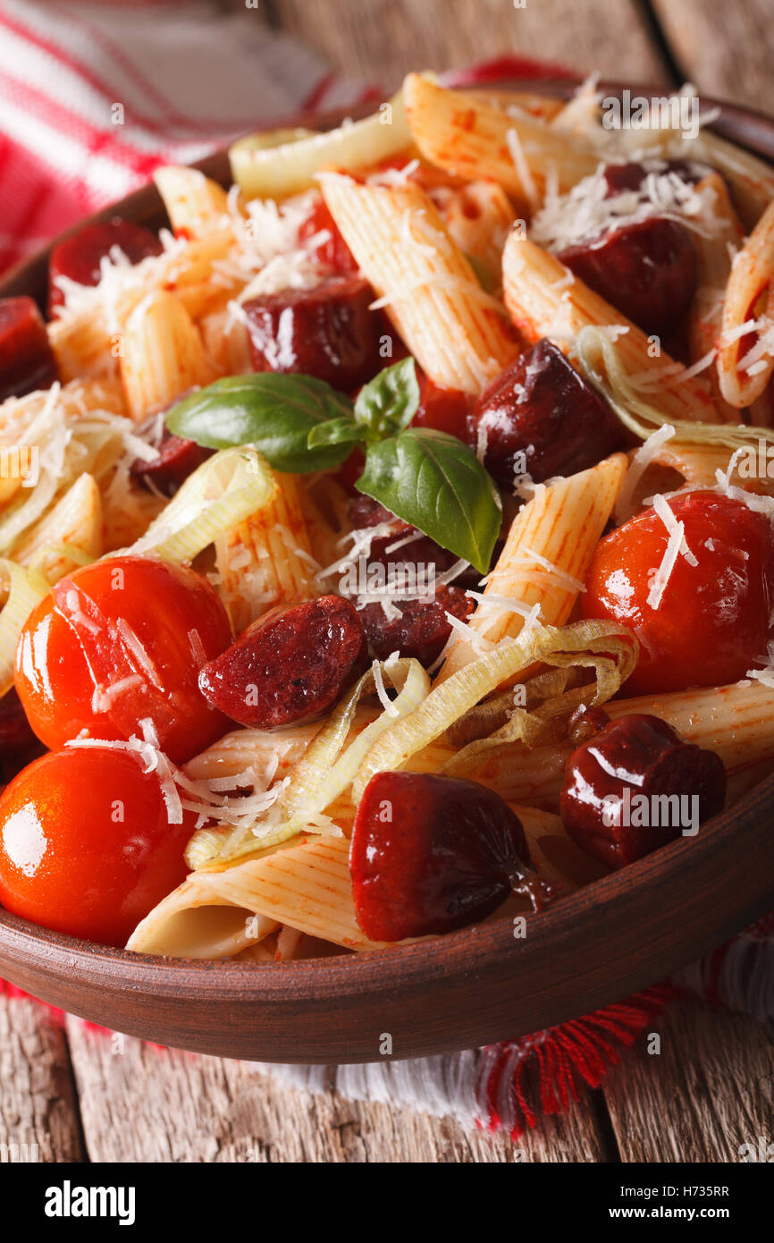 penne pasta with sausage and tomatoes in a bowl macro. Vertical Stock Photo