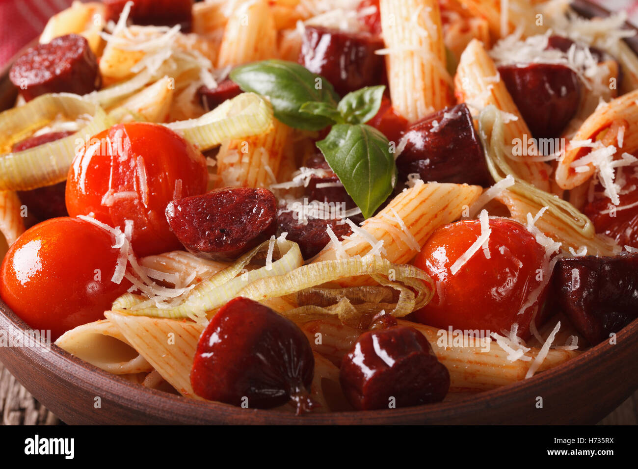 penne pasta with sausage and tomatoes in a bowl macro. horizontal Stock Photo