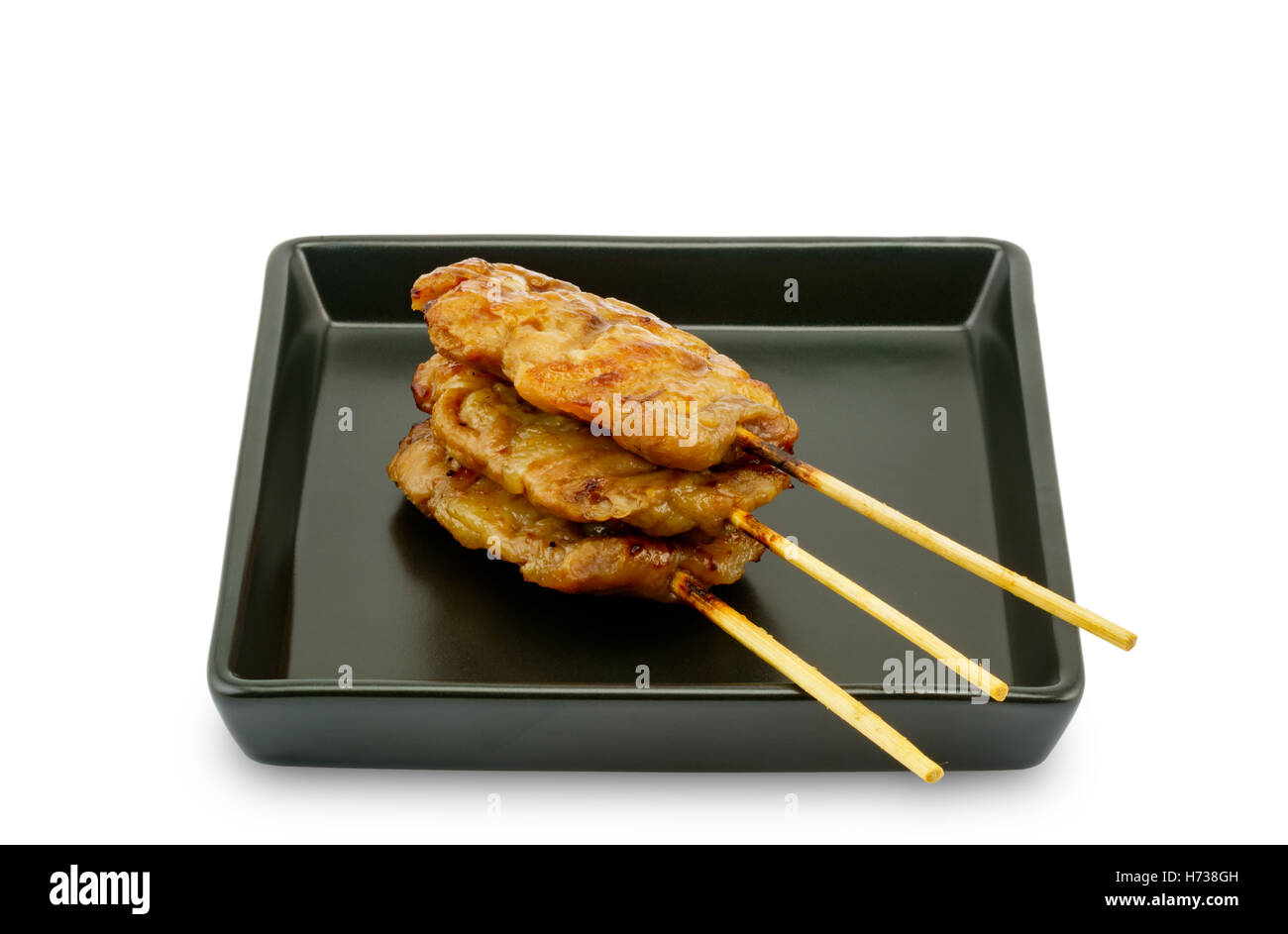 Thai styled grill pork barbeque in black plate on white background Stock Photo