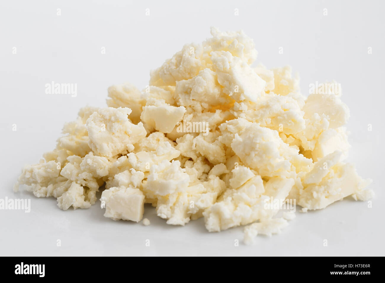 Crumbled white feta cheese isolated on white surface. Stock Photo