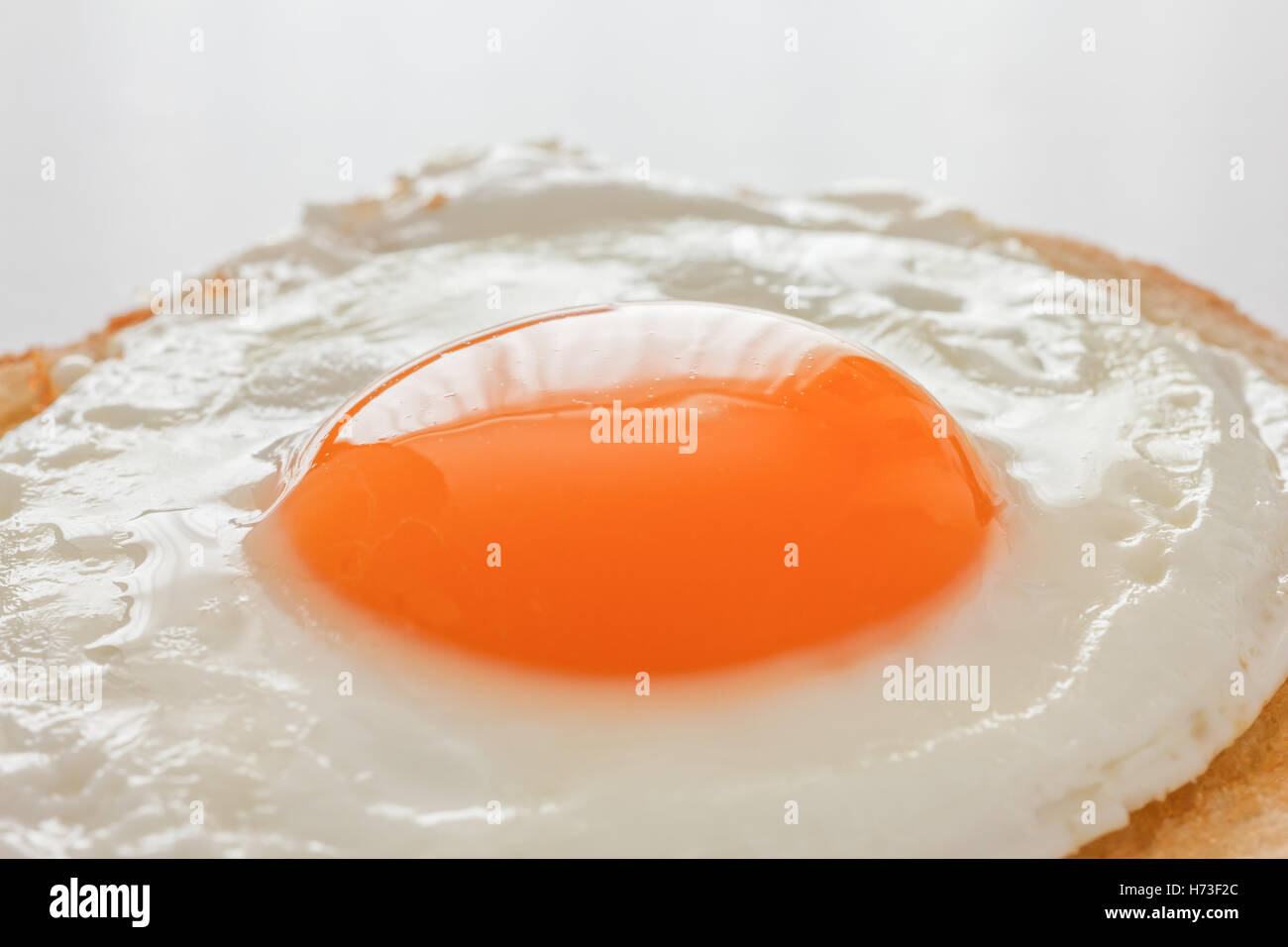 Close up of a fried egg on white toast Stock Photo