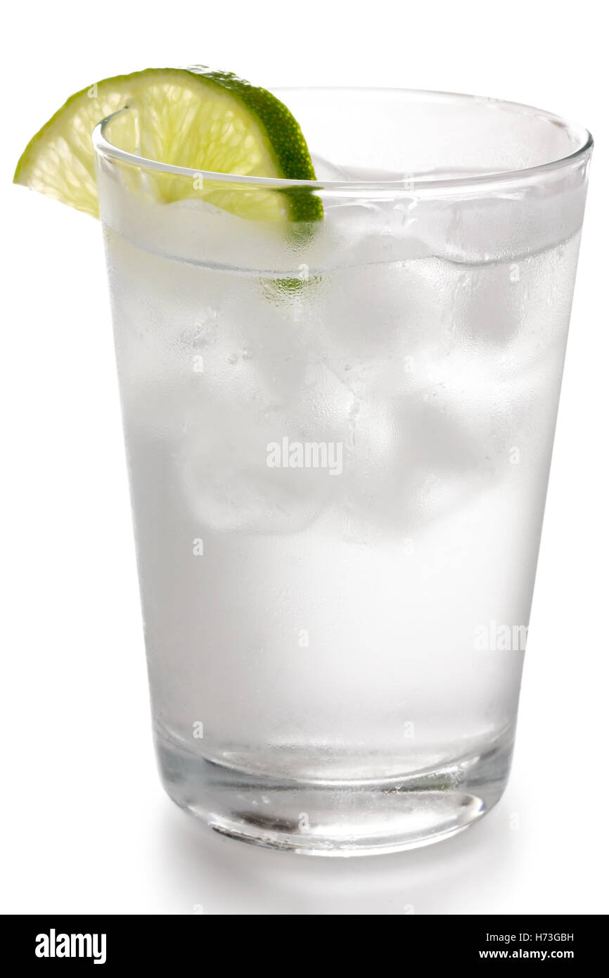 Detail of a simple glass of water with floating ice cubes and lime ...