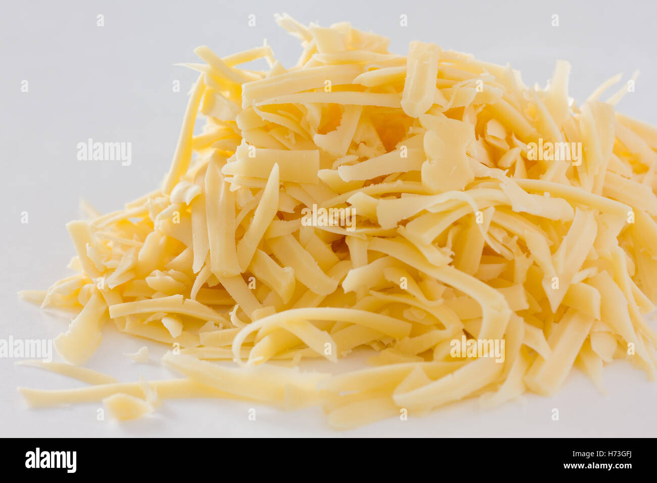 Grated yellow cheese on white Stock Photo Alamy