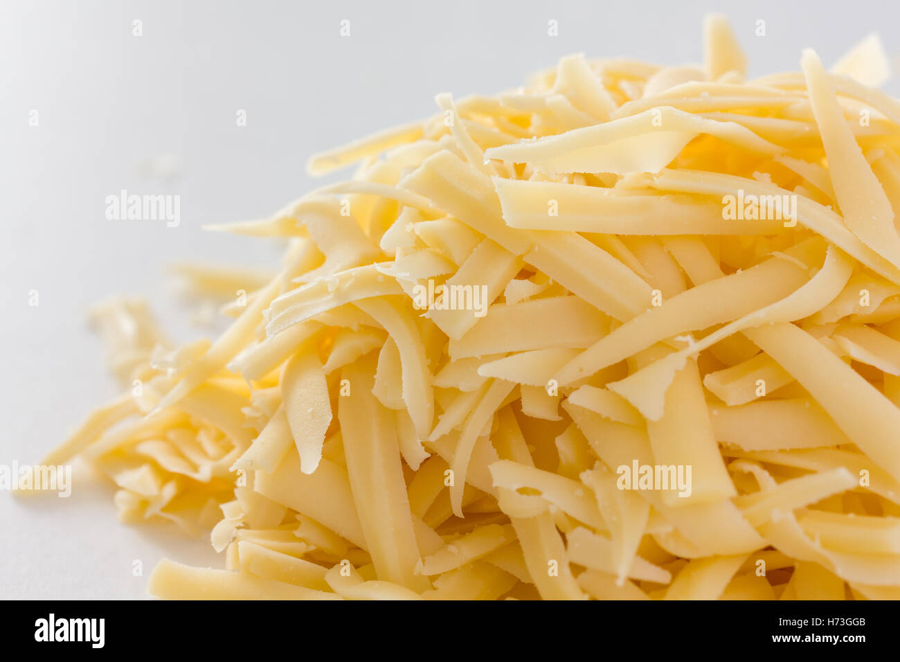 Grated yellow hard cheese on white Stock Photo