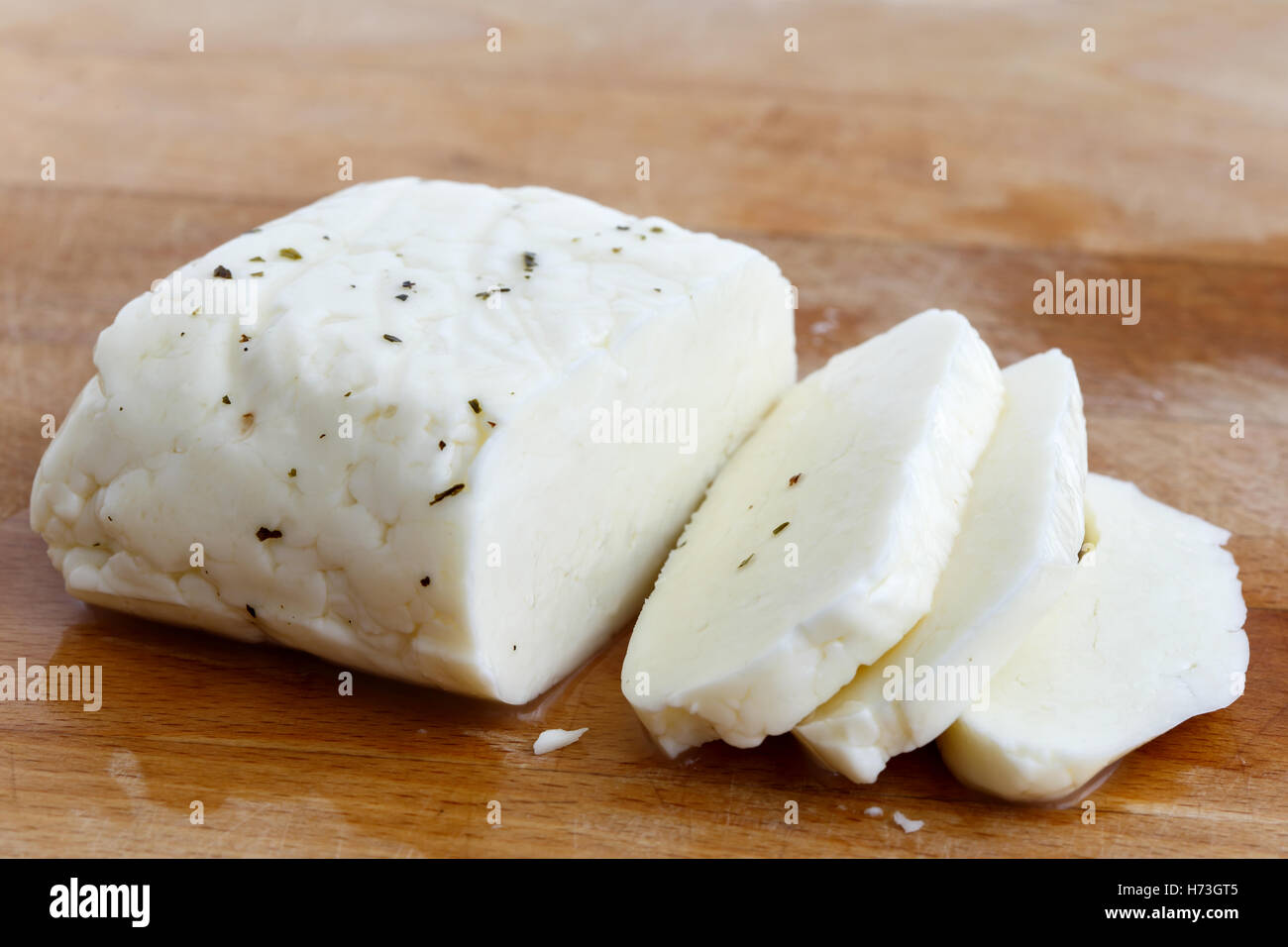 Sliced halloumi cheese with mint on wooden board in perspective. Stock Photo