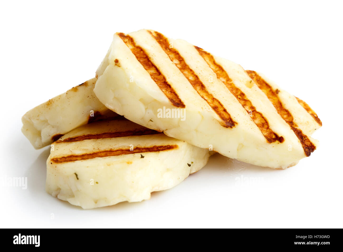 Three grilled slices of halloumi cheese isolated on white in perspective. With grill marks. Stock Photo