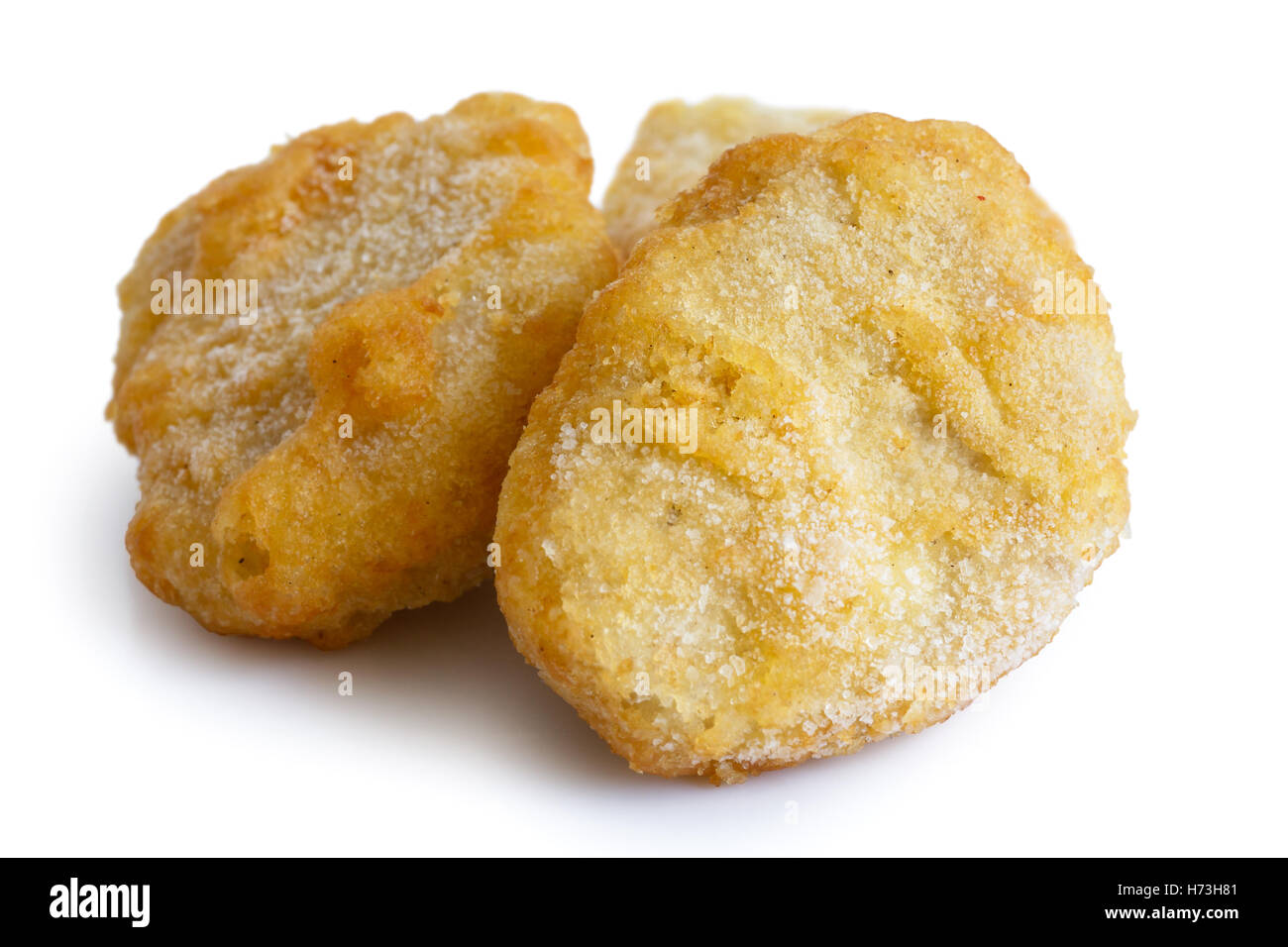 Frozen battered chicken nuggets uncooked and isolated on white in perspective. Stock Photo