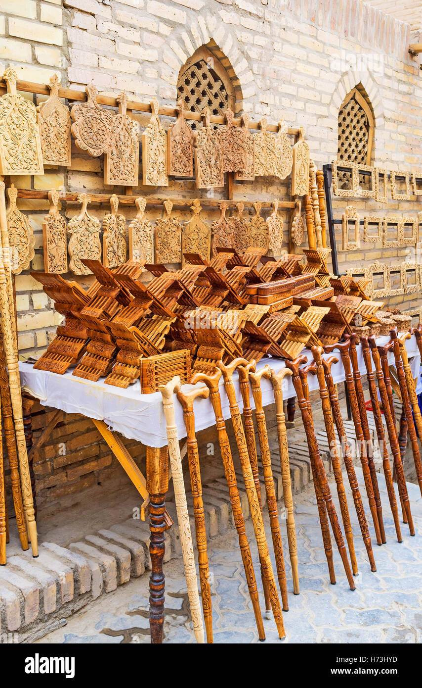 The stall with the wide range of the carved walking sticks, bookends and vegetable boards, Khiva, Uzbekistan. Stock Photo