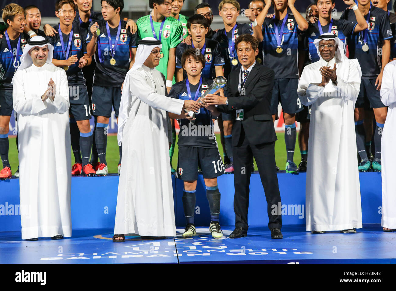 Riffa, Bahrain. 30th Oct, 2016. Daisuke Sakai, Akira Nishino (JPN) Football/ Soccer : Daisuke Sakai of Japan receives the trophy after winning the AFC  U-19 Championship Bahrain 2016 Final match between Japan 0(5-3)0