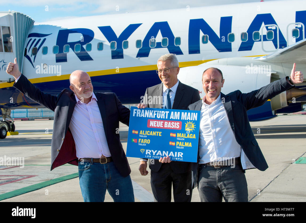 David O·Brien (L-R, Chief Commercial Officer at Ryanair), Stefan Schulte (CEO of Fraport AG) and Kenny Jacobs (Chief Marketing Officer Ryan Air) stand with a sign that reads 'Frankfurt am Main new base' at the airport in Frankfurt am Main, Germany, 02 November 2016. Two Lufthansa airplanes can be seen in the background. Airport operator Fraport and the Irish discount airline Ryanair are delivering statements at a joint press conference on the Ryanair's future offerings at the Frankfurt am Main airport. For the occasion, an airplane from Rynair landed for the first time at the airport. Photo: A Stock Photo