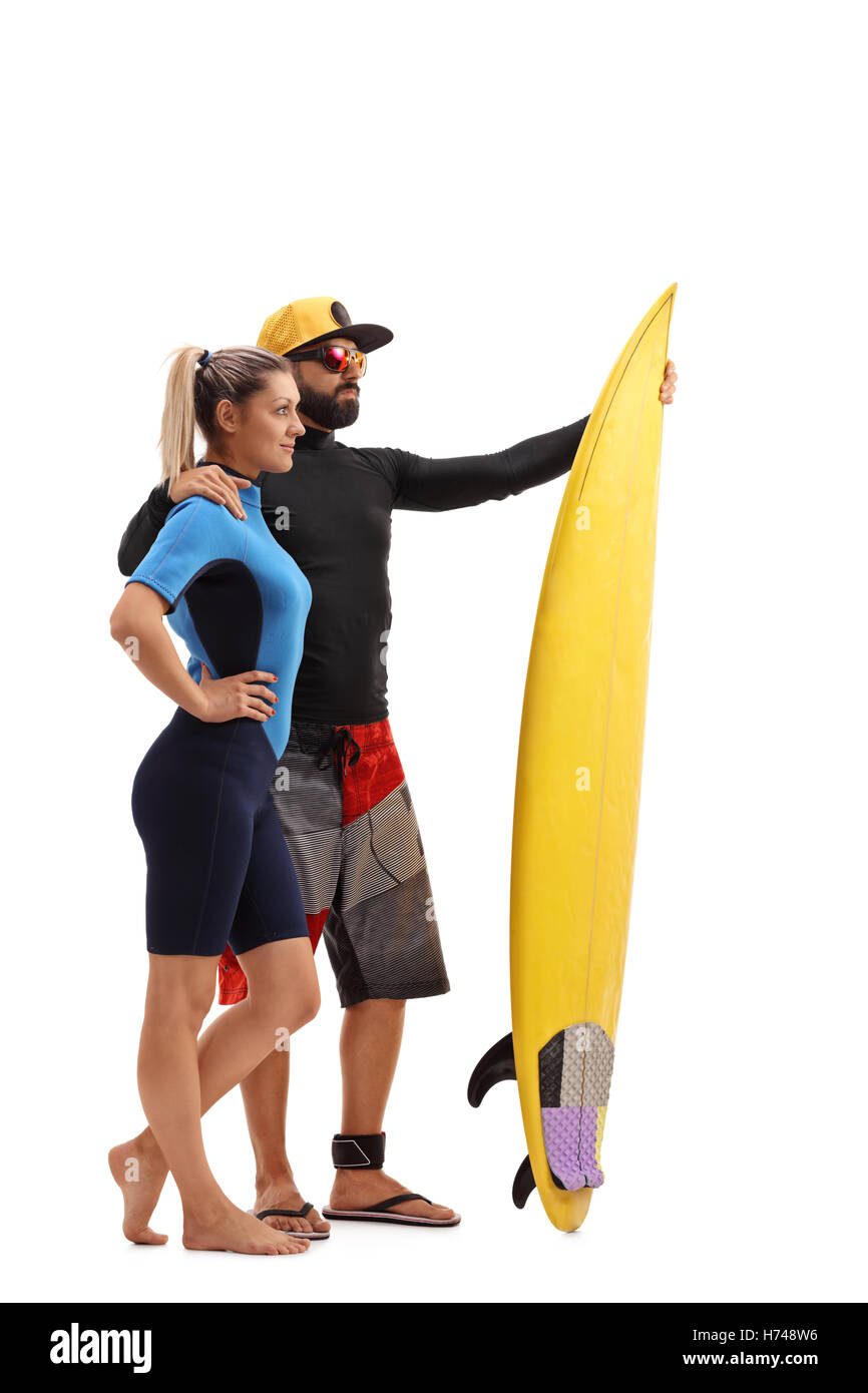 Full length profile shot of a male and female surfer posing with a surfboard isolated on white background Stock Photo