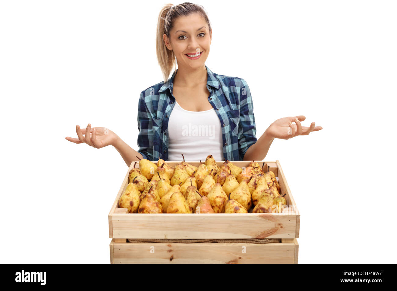 Happy female farmer posing with a crate full of pears and gesturing ...